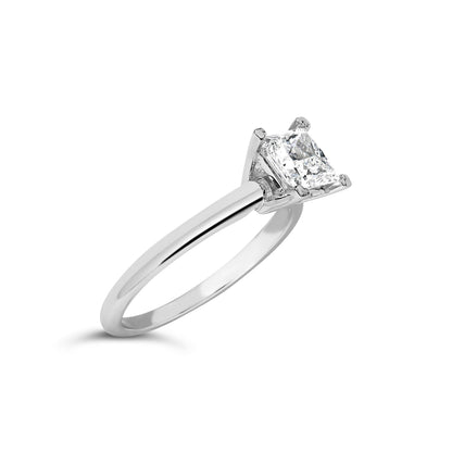 White metal ring with a princess shape white gemstone in prong setting, shown at an angled close-up.