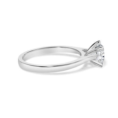 Side angle view of a white metal ring with a single round white gemstone in a four-prong setting.