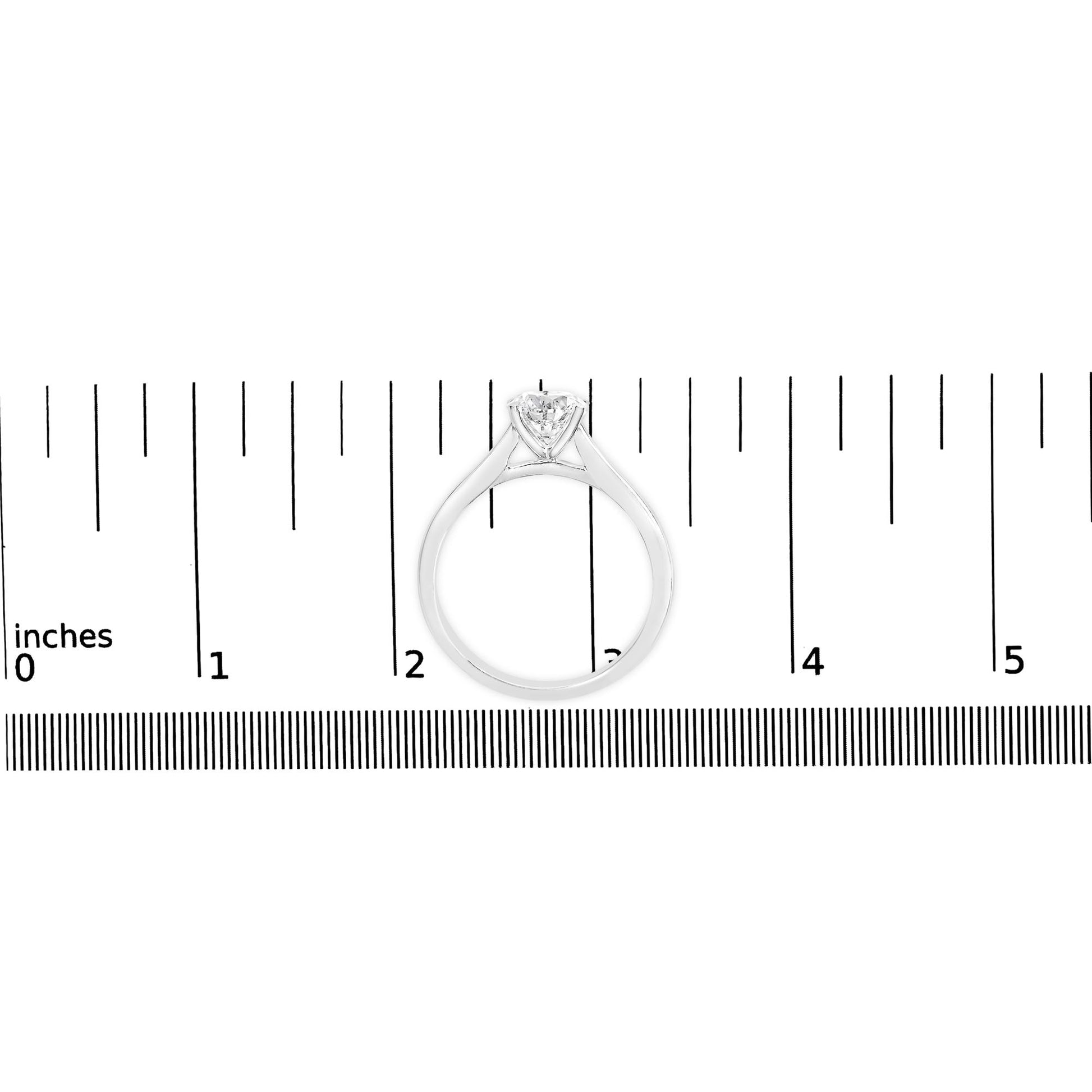 White metal ring with a round white gemstone in a four-prong setting, shown from the front on a ruler for size reference.