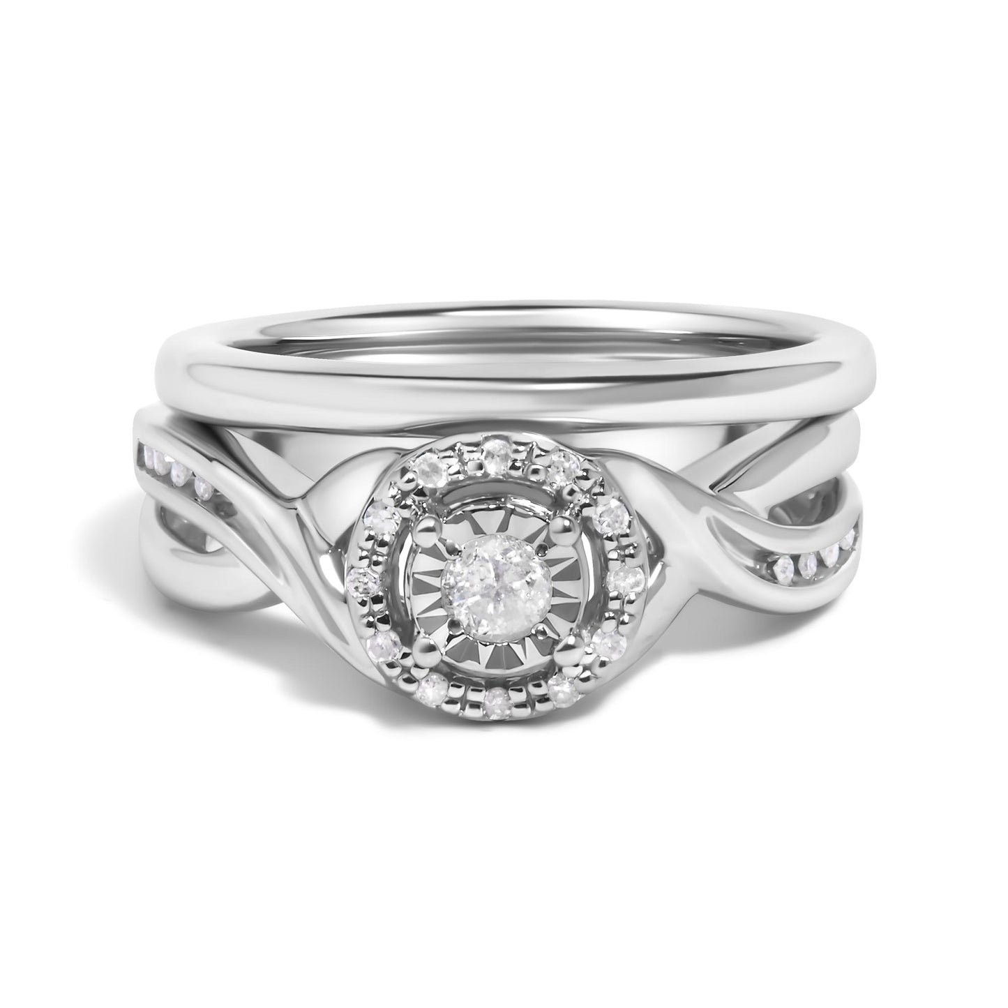 Close-up front view of a white metal ring set featuring a central round white gemstone surrounded by smaller round white gemstones in prong settings, with an intertwined band design accented by additional small round white gemstones.