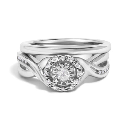 Close-up front view of a white metal ring set featuring a central round white gemstone surrounded by smaller round white gemstones in prong settings, with an intertwined band design accented by additional small round white gemstones.