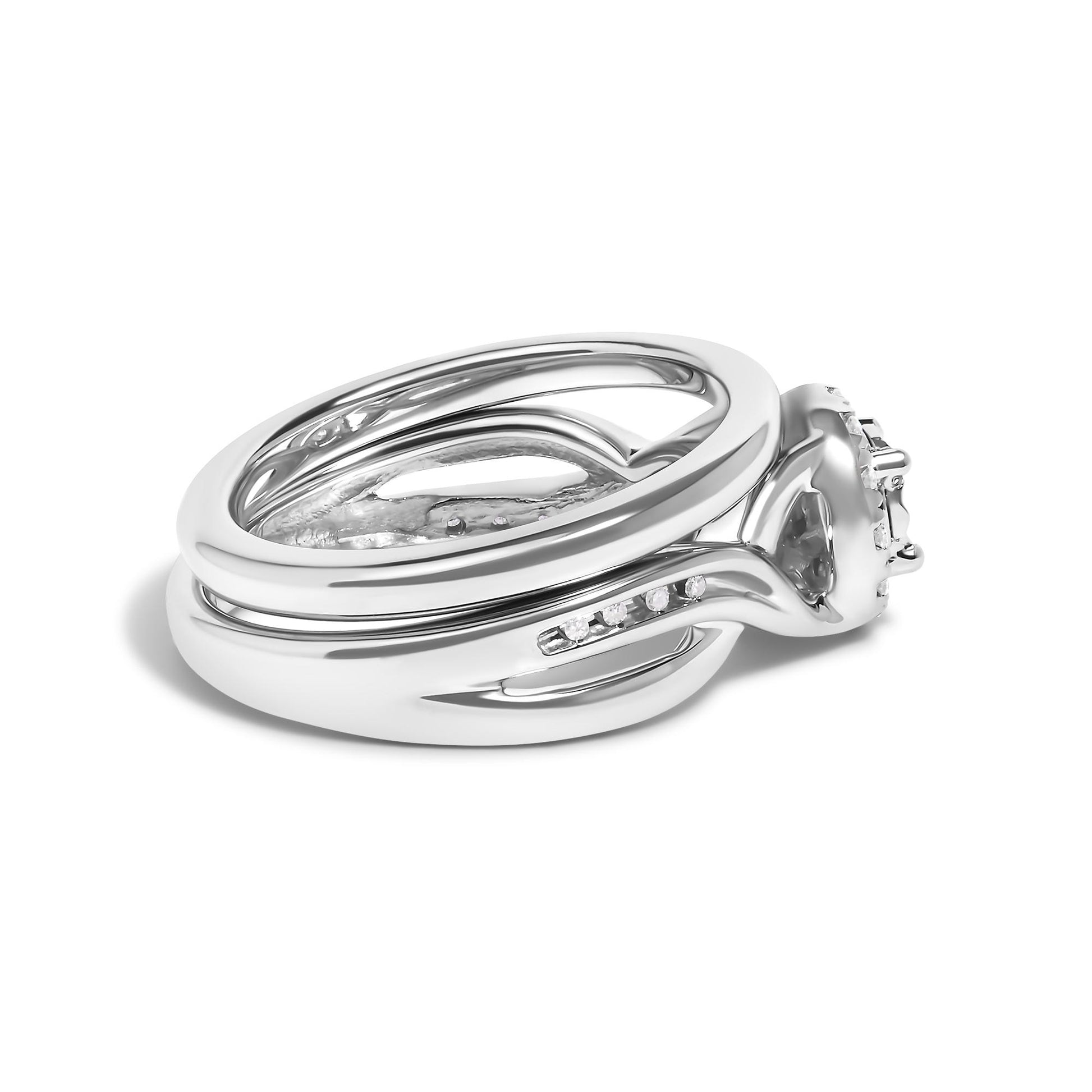 Close-up side angle of a white metal ring featuring one larger round prong-set white gemstone at the top, a band with twelve small round prong-set white gemstones, and additional small round prong-set white gemstones on the sides.