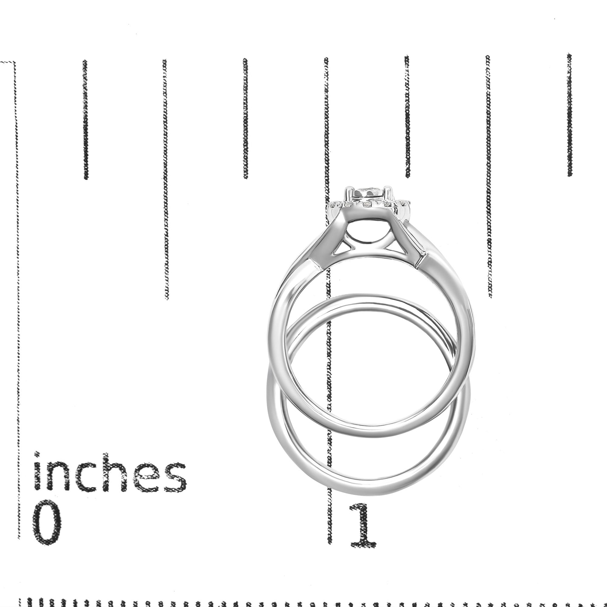 Front angle of a white metal ring with a center round white gemstone in prong setting, surrounded by multiple smaller round white gemstones, placed on a ruler for size reference.