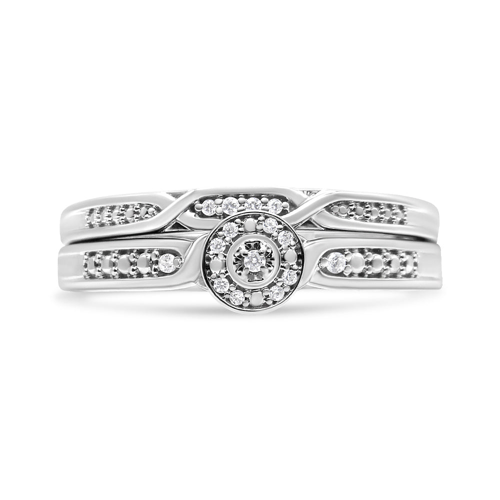 White metal ring set shown from the front with a round center cluster of white gemstones and intricate band details featuring rows of small white gemstones.