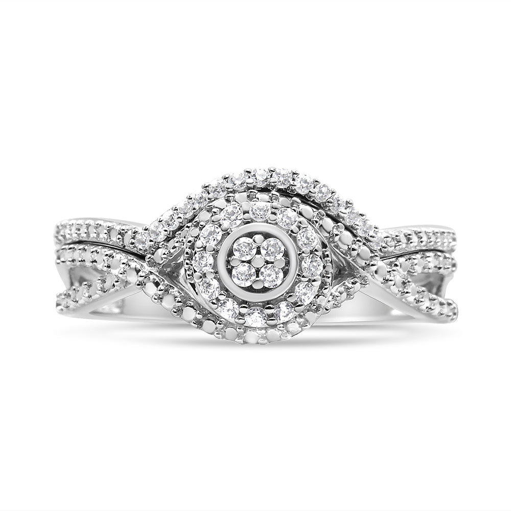 Close-up front view of a white metal ring featuring a twisted band design with multiple round white gemstones in prong settings arranged in concentric patterns.
