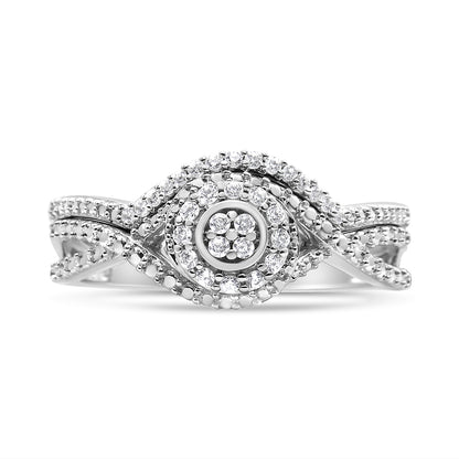 Close-up front view of a white metal ring featuring a twisted band design with multiple round white gemstones in prong settings arranged in concentric patterns.
