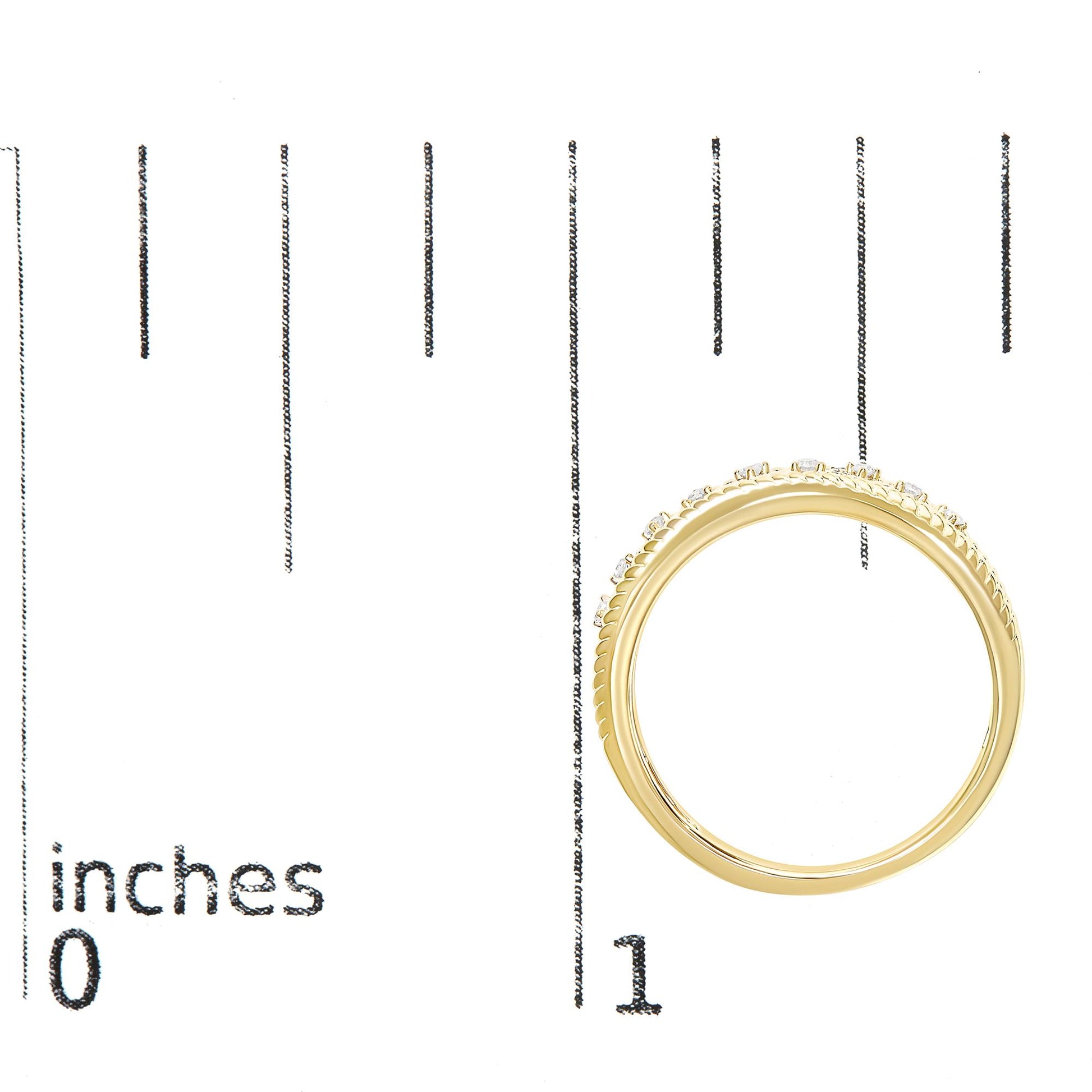 Top-down view of a yellow ring with round white gemstones in prong settings, placed on a ruler for size reference.