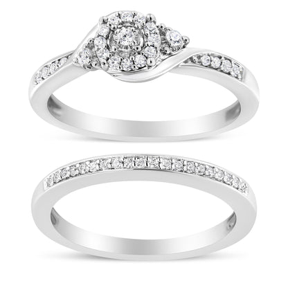 Top view of two white metal rings with round white gemstones in prong settings; the upper ring features a cluster center design and side gemstones, while the lower ring has a row of gemstones along the band.
