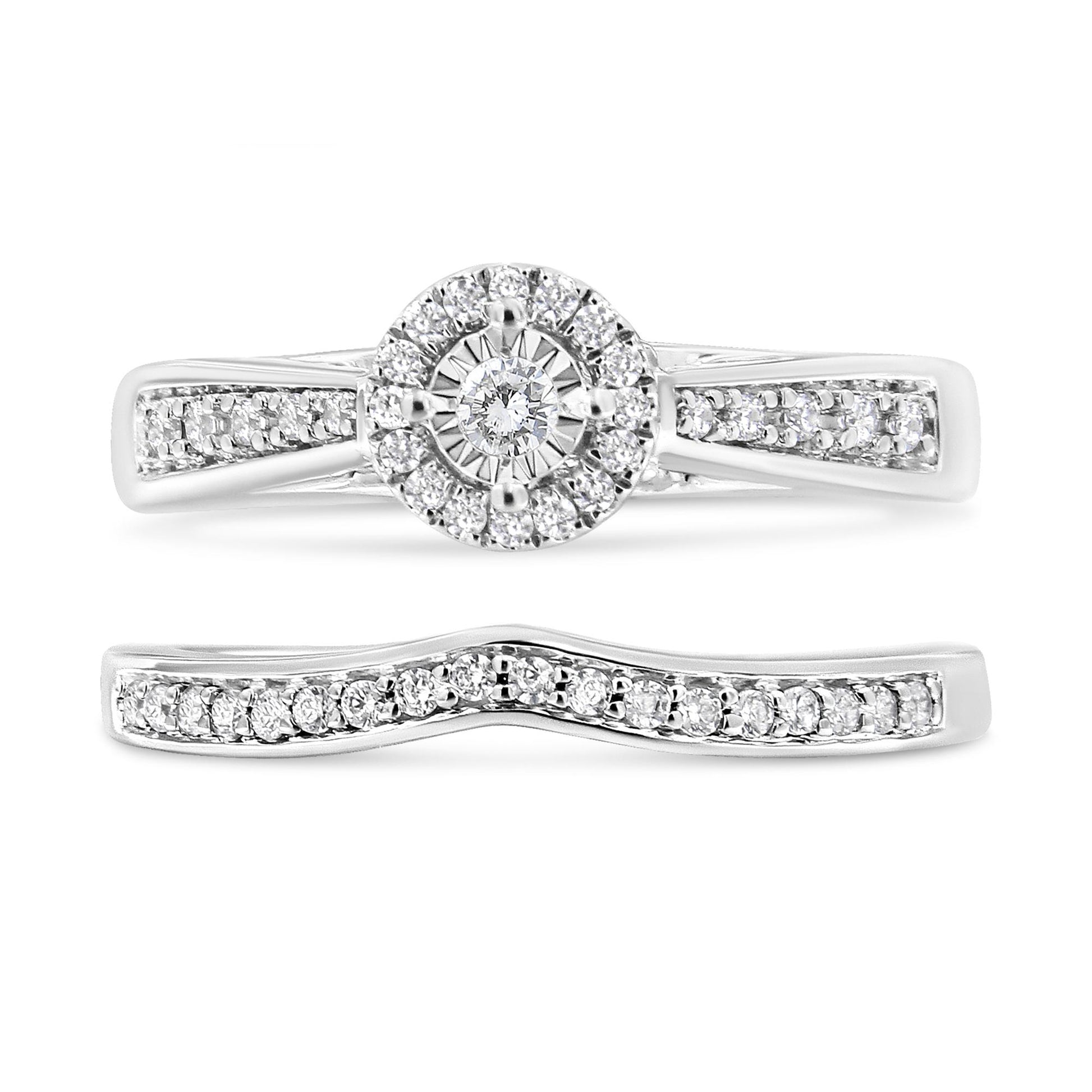 Front-facing view of two white metal rings; one with a round center setting surrounded by a halo of white gemstones and additional white gemstones along the band, paired with a contoured band featuring a row of white gemstones.