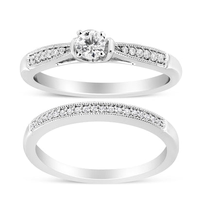 Two white metal rings shown from a front angle; one features a central round white gemstone in a four-prong setting with additional small round white gemstones set along the band, the other is a full eternity style ring with small round white gemstones in a shared prong setting along the band.