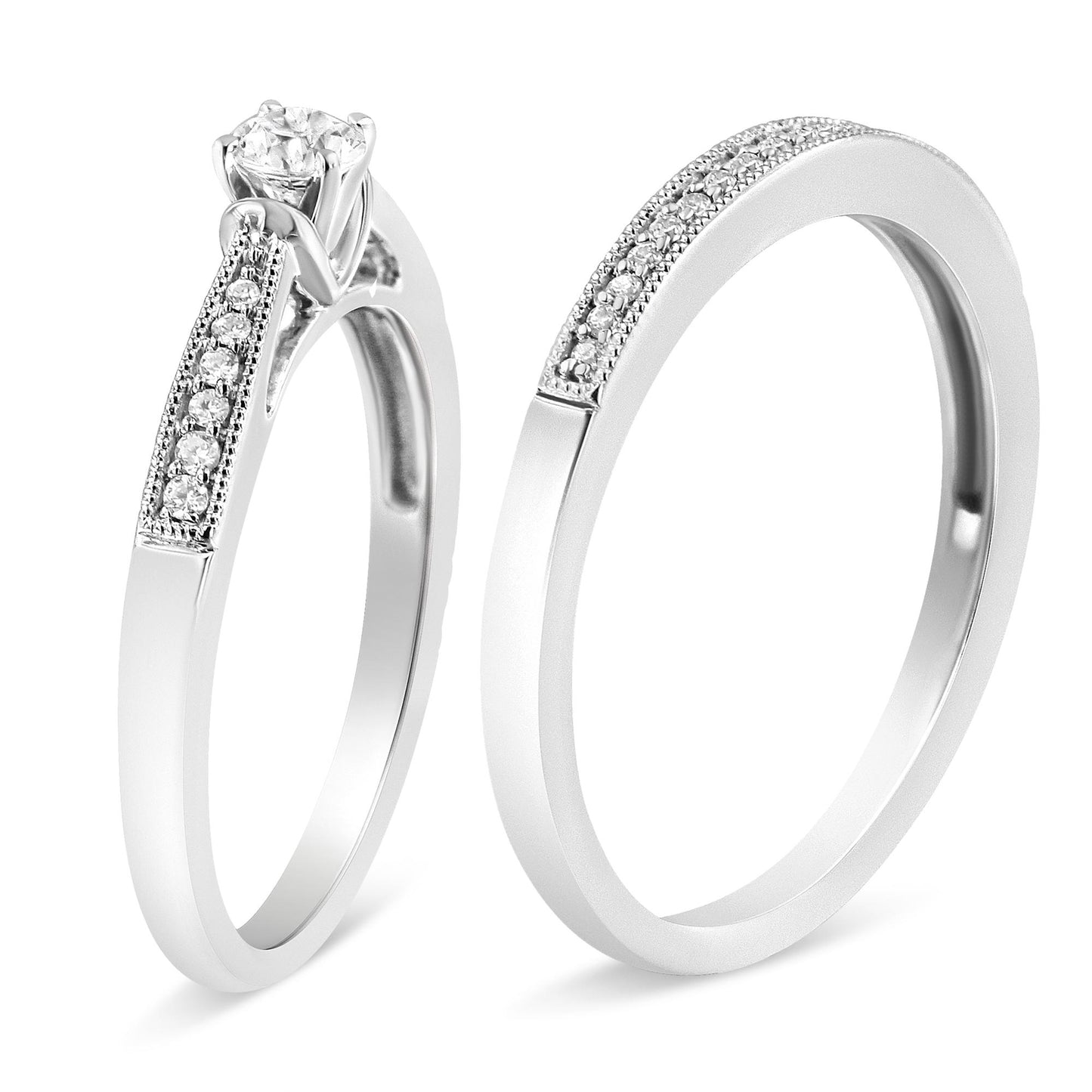 Two white metal rings shown in a close-up angled side view, each adorned with multiple small white gemstones on the bands, one featuring a single larger white gemstone in a four-prong setting.