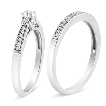 Two white metal rings shown in a close-up angled side view, each adorned with multiple small white gemstones on the bands, one featuring a single larger white gemstone in a four-prong setting.
