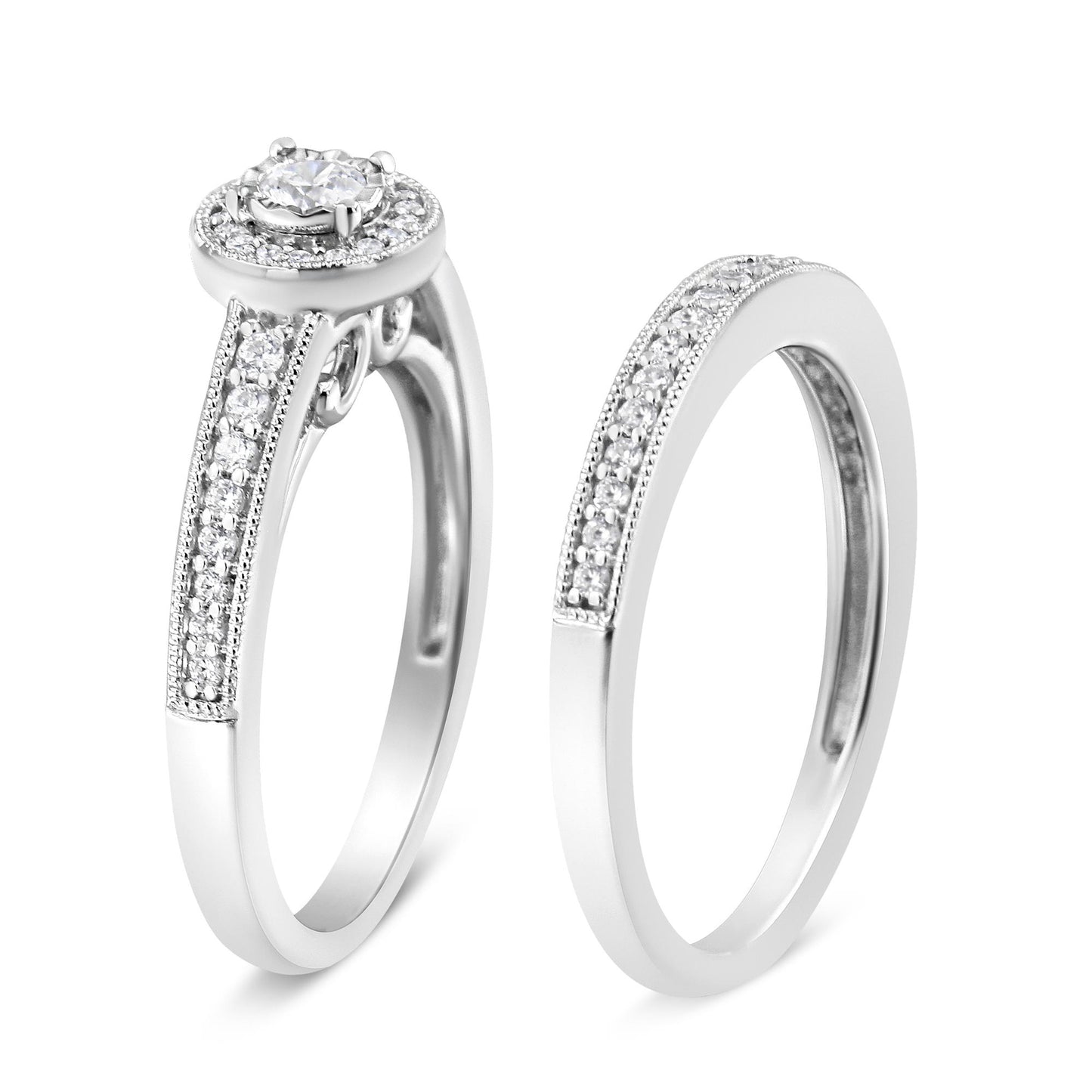 Two white metal rings shown at a slight angle, one with a central round white gemstone in a raised setting surrounded by smaller white gemstones on the band, the other ring featuring a row of small white gemstones set in a pave style on the band.
