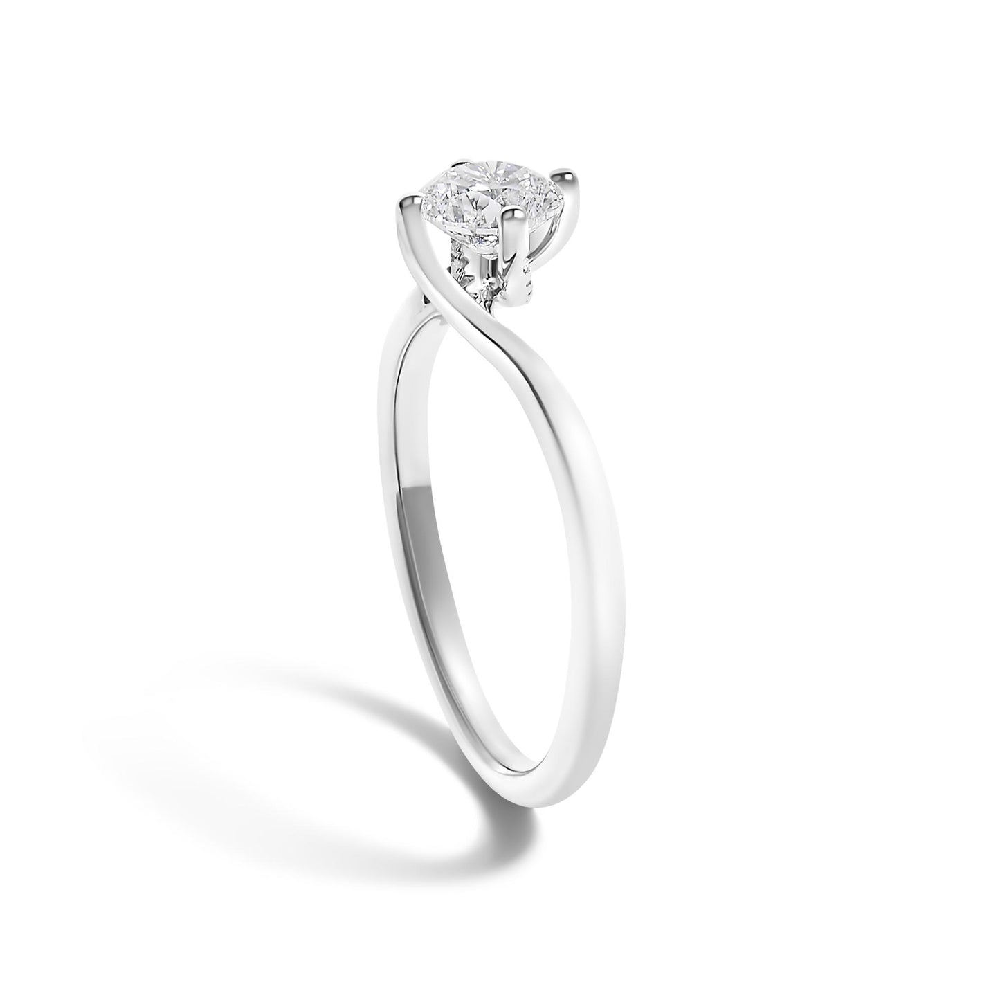 White metal ring with a twisted band design and a single round white gemstone in a four-prong setting, shot at a slight angle against a white background.