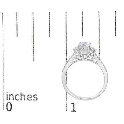 White metal ring with a round center gemstone in a four-prong setting, surrounded by smaller white gemstones in micro-pave settings along the band, shown from the side on a ruler for size reference.