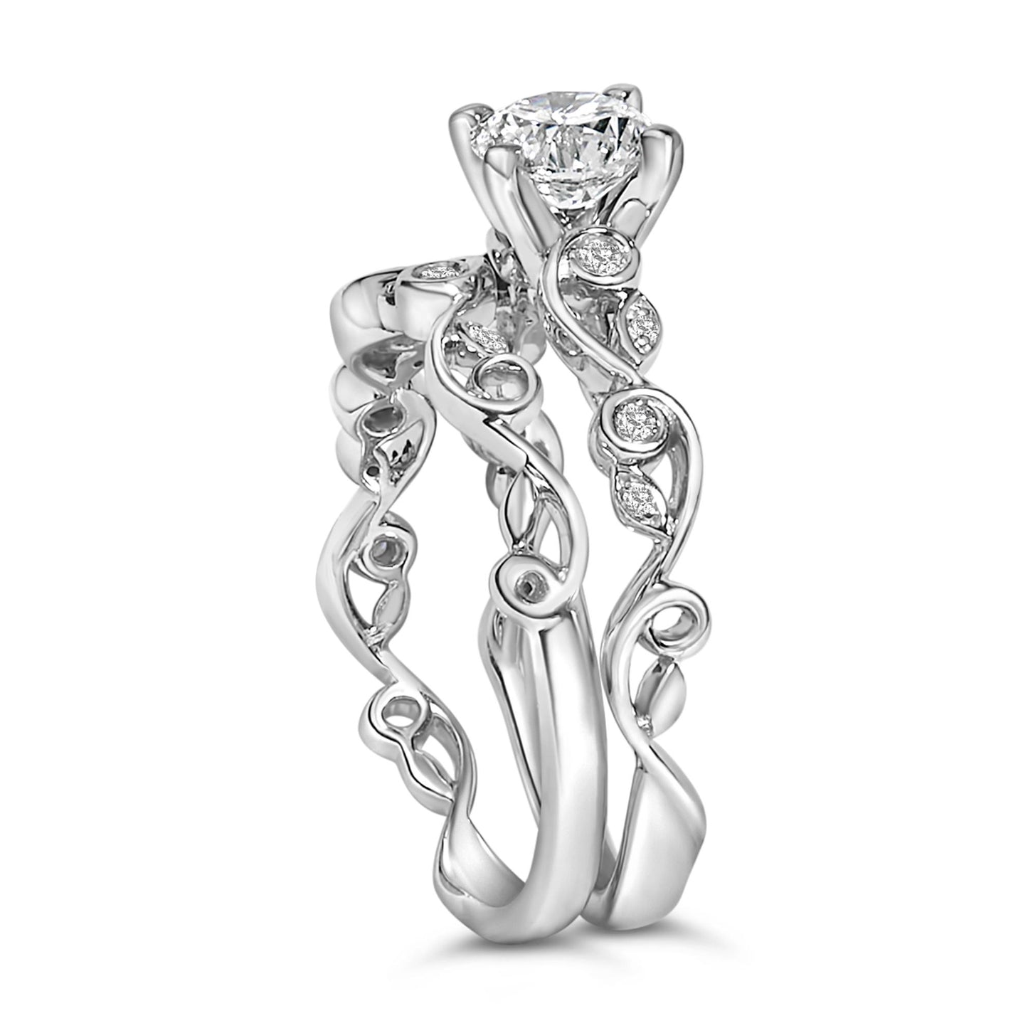 Close-up front angle of two white rings with swirling bands, each adorned with round white gemstones in prong settings.