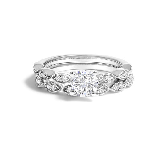 White metal ring set viewed from the front, featuring a large round white gemstone in prong setting at the center, surrounded by an intricate band decorated with multiple smaller round white gemstones in prong settings arranged in a leaf-like pattern.