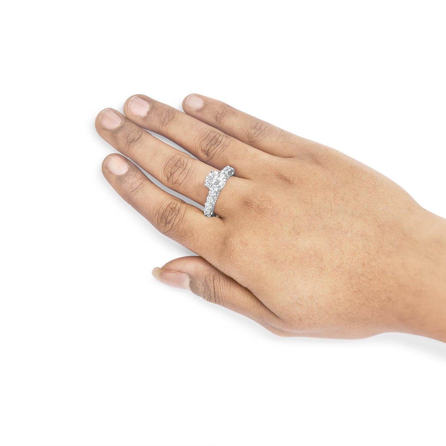 White metal ring with a round prong-set white gemstone center and a band featuring shared prong-set white gemstones, shown worn on a model's hand from a top angle.