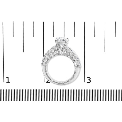 White metal ring with one round prong-set white gemstone and a band decorated with multiple round shared prong-set white gemstones, shown from front angle on a measurement scale.