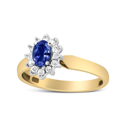 Yellow metal ring with an oval blue gemstone surrounded by round white gemstones, shown from a side angle.