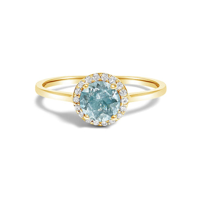 Front view of a yellow metal ring with a round blue gemstone in a four-prong setting, surrounded by a halo of round white gemstones in shared prong settings.