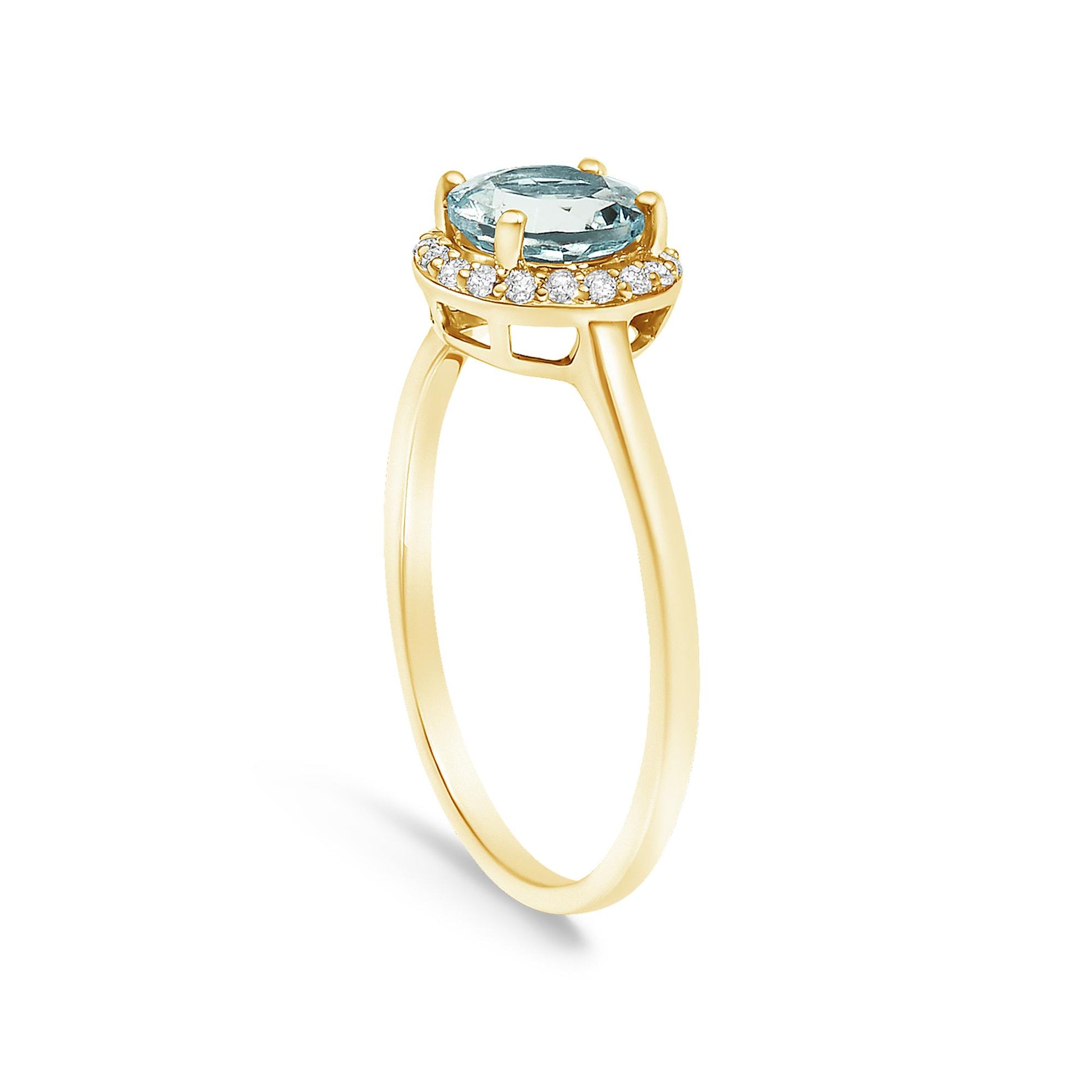 Yellow ring shown at an angle with a round blue gemstone in a four-prong setting at the center, surrounded by a halo of round white gemstones in shared prong settings.