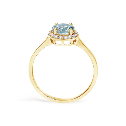 Yellow metal ring shown from the side angle featuring a blue round gemstone set with four prongs in the center and surrounded by multiple small white round gemstones in a shared prong setting.