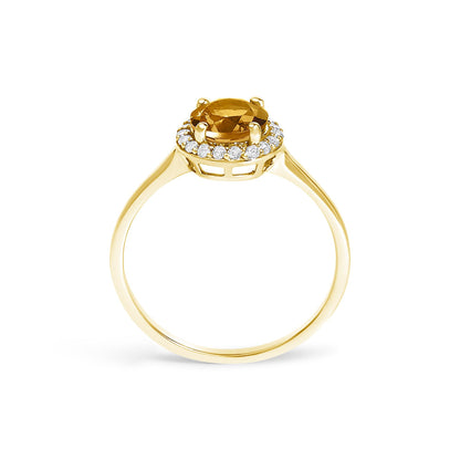 Yellow metal ring with a round orange gemstone center held by four prongs, surrounded by a halo of small round white gemstones in shared prong setting, shown in a front profile angle.