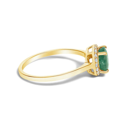 Side angle close-up of a yellow ring with a round green gemstone set in a four-prong setting, surrounded by small round white gemstones in a shared prong setting.