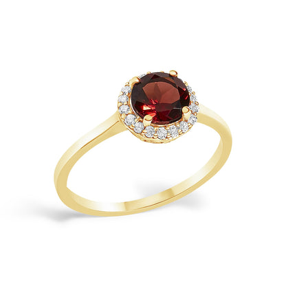 Yellow metal ring with a round red gemstone in a four-prong setting, surrounded by white round gemstones in shared prong settings, shown at an angled close-up.