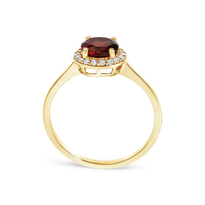 Yellow metal ring with a round red gemstone center set in a 4-prong setting, surrounded by round white gemstones in shared prong settings, shown from a side angle.