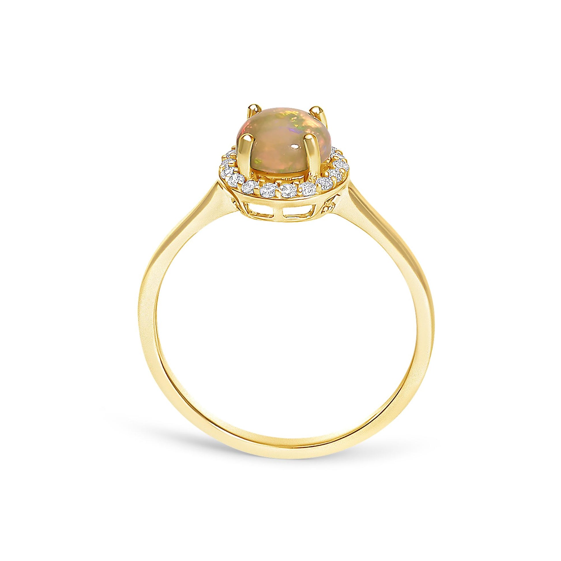 Yellow metal ring with a round multicolor opal gemstone in a four-prong setting, surrounded by a halo of round white gemstones in shared prong settings, shown from the side angle on a white background.