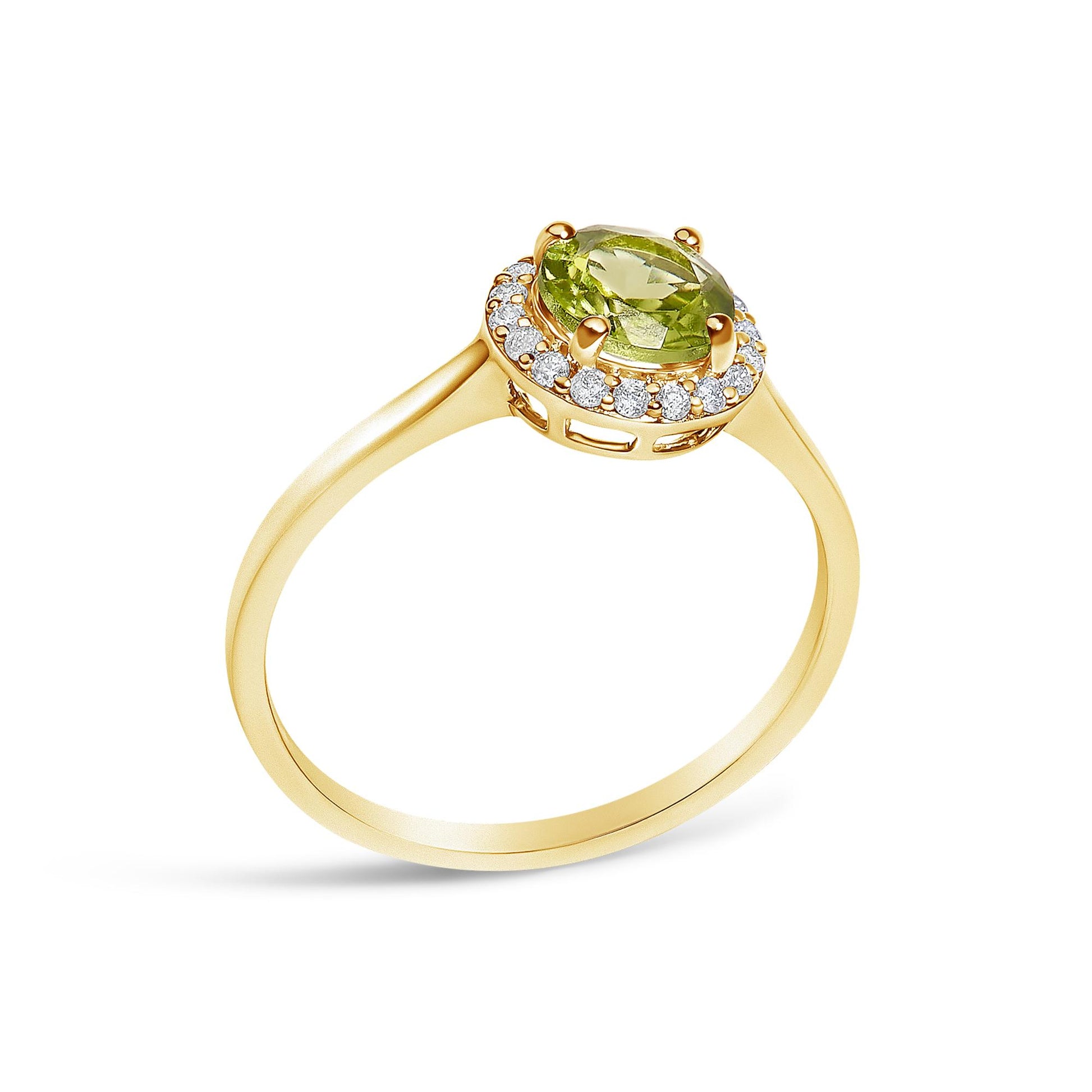 Yellow metal ring with a round green gemstone center set with four prongs and surrounded by a halo of round white gemstones in shared prong setting, shown from a tilted top angle on a white background.