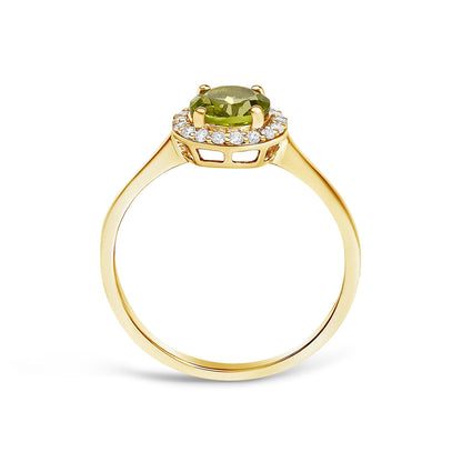 Yellow metal ring shown from the side angle, featuring a central round green gemstone set with four prongs, surrounded by a halo of round white gemstones in a shared prong setting.
