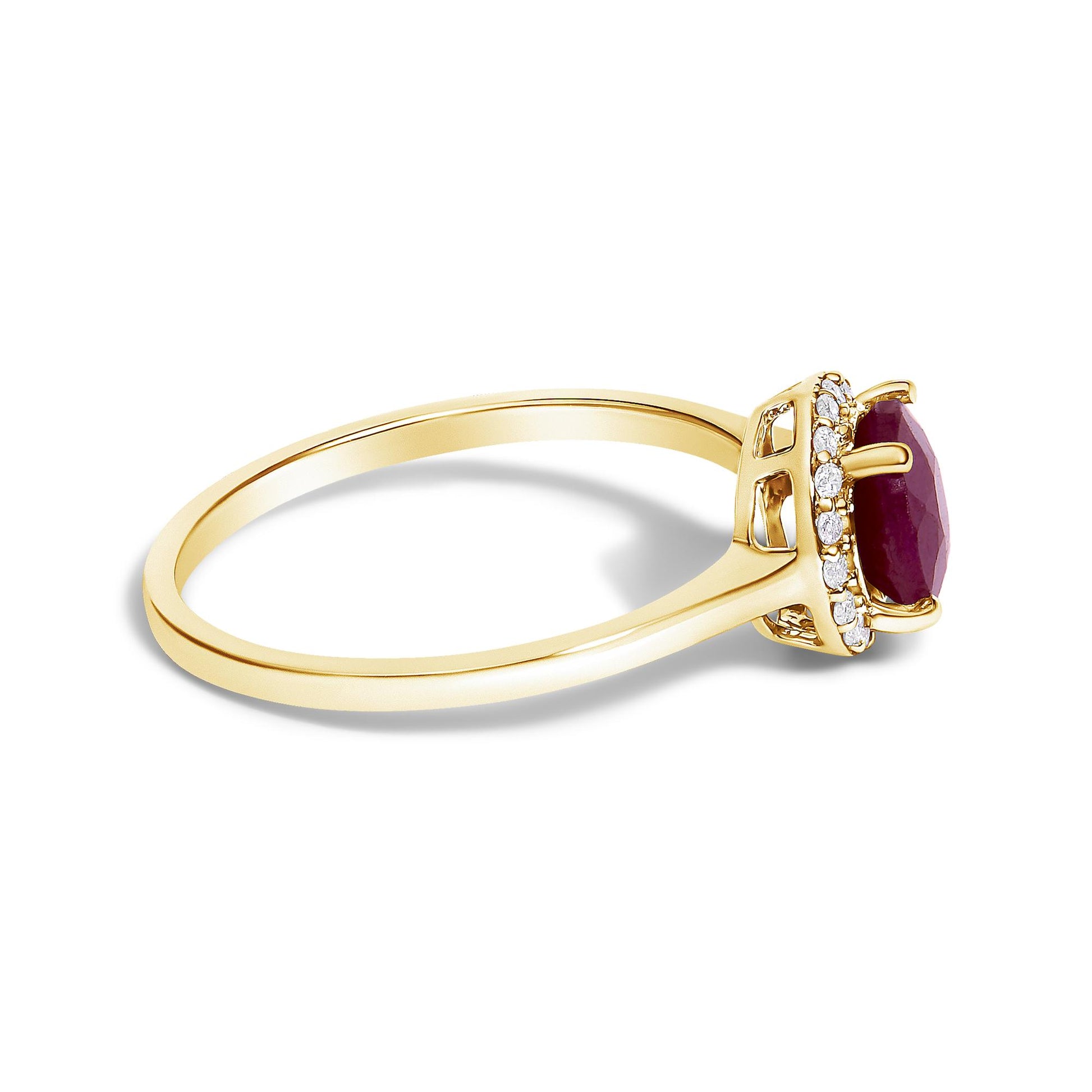 Side angle view of a yellow metal ring featuring a round red gemstone held by four prongs, surrounded by a halo of round white gemstones in shared prong settings.