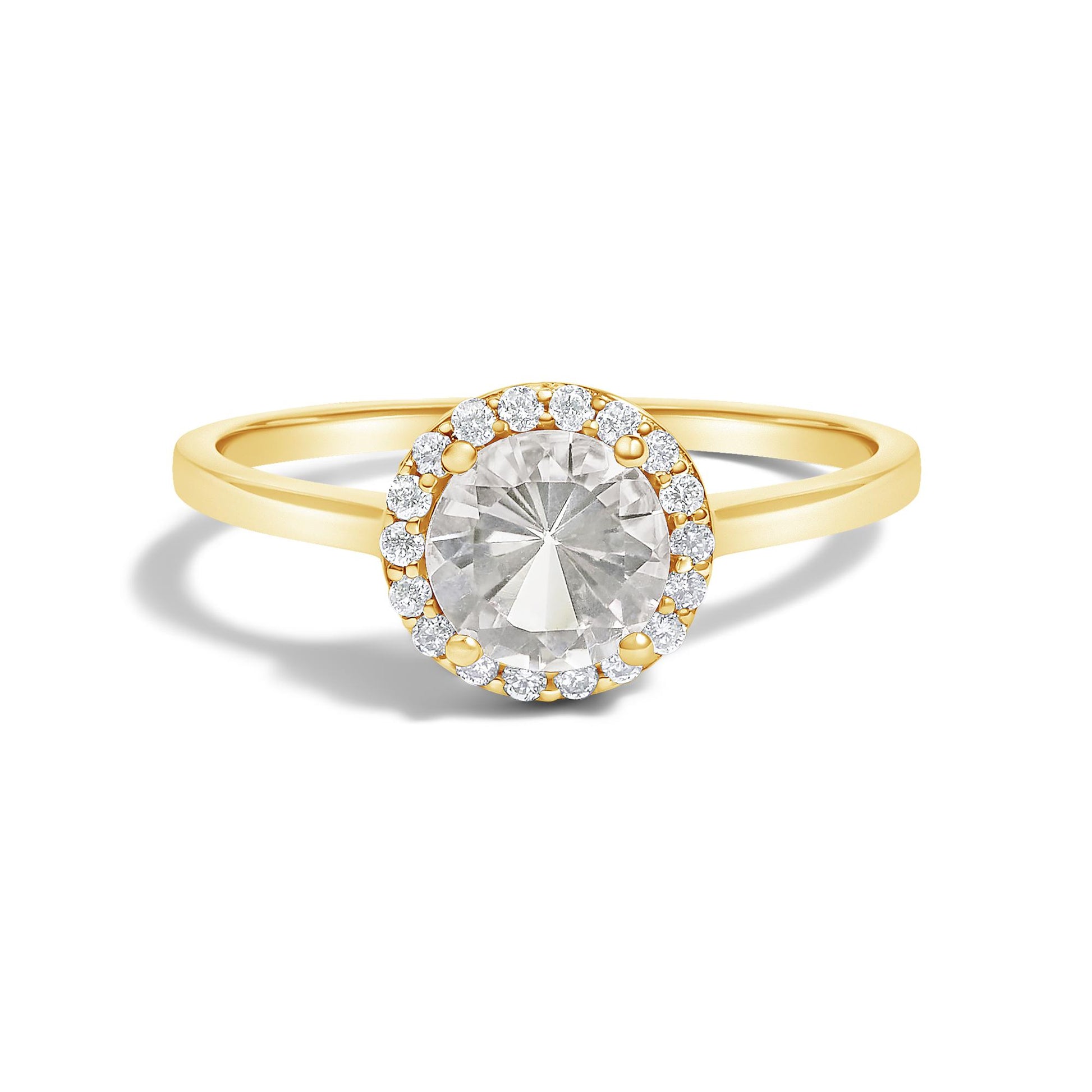 Yellow metal ring with a large round white gemstone in a 4-prong setting, surrounded by smaller round white gemstones in a shared prong setting, front-facing angle on a white background.
