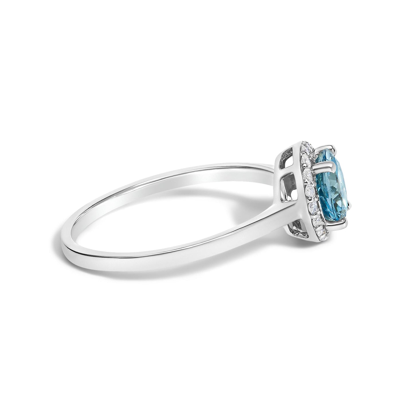 Side angle view of a white ring with a round blue gemstone in a four-prong setting, surrounded by round white gemstones in a shared prong setting.