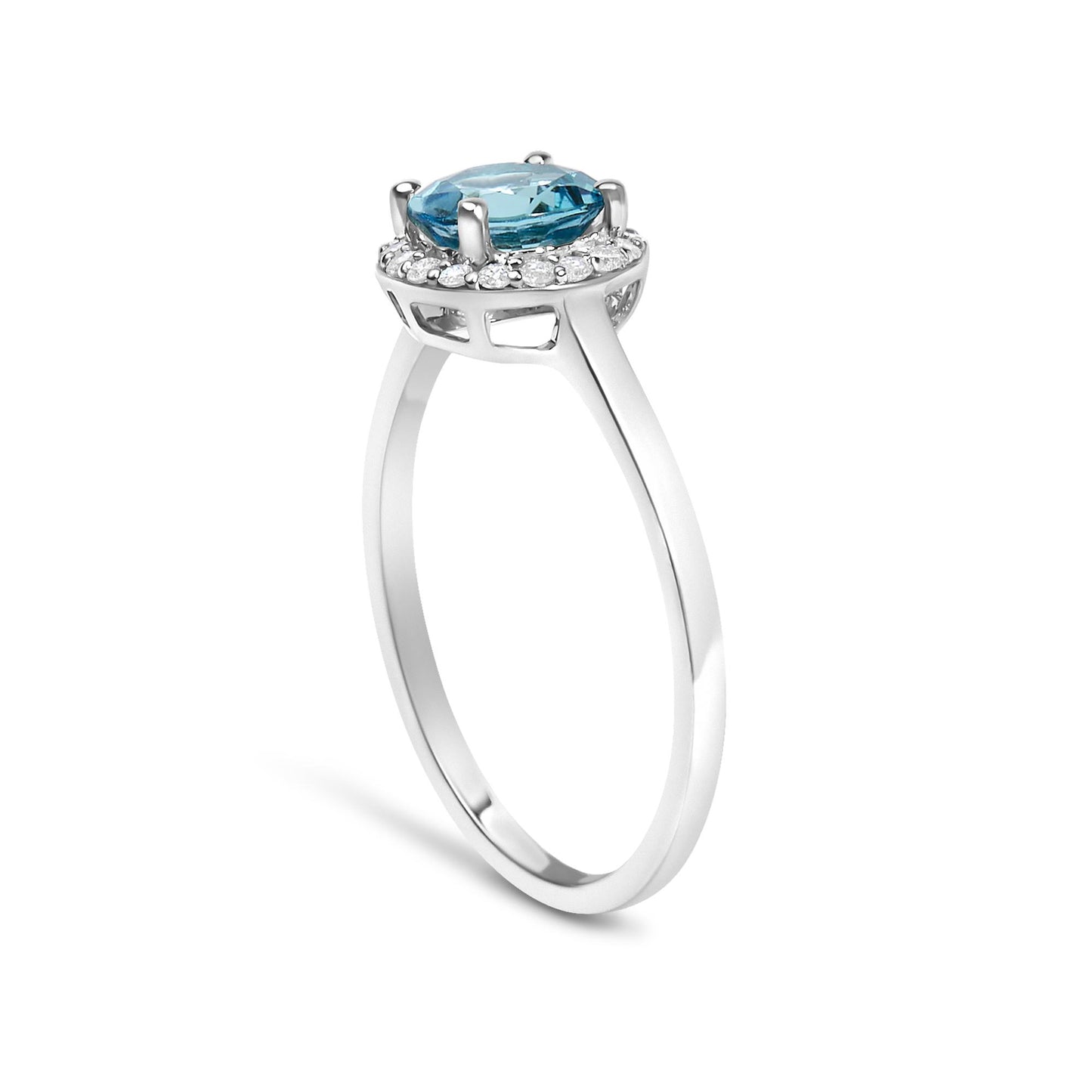 White metal ring shown from a side angle with a round blue gemstone in a four-prong setting surrounded by a shared prong setting of small white round gemstones.