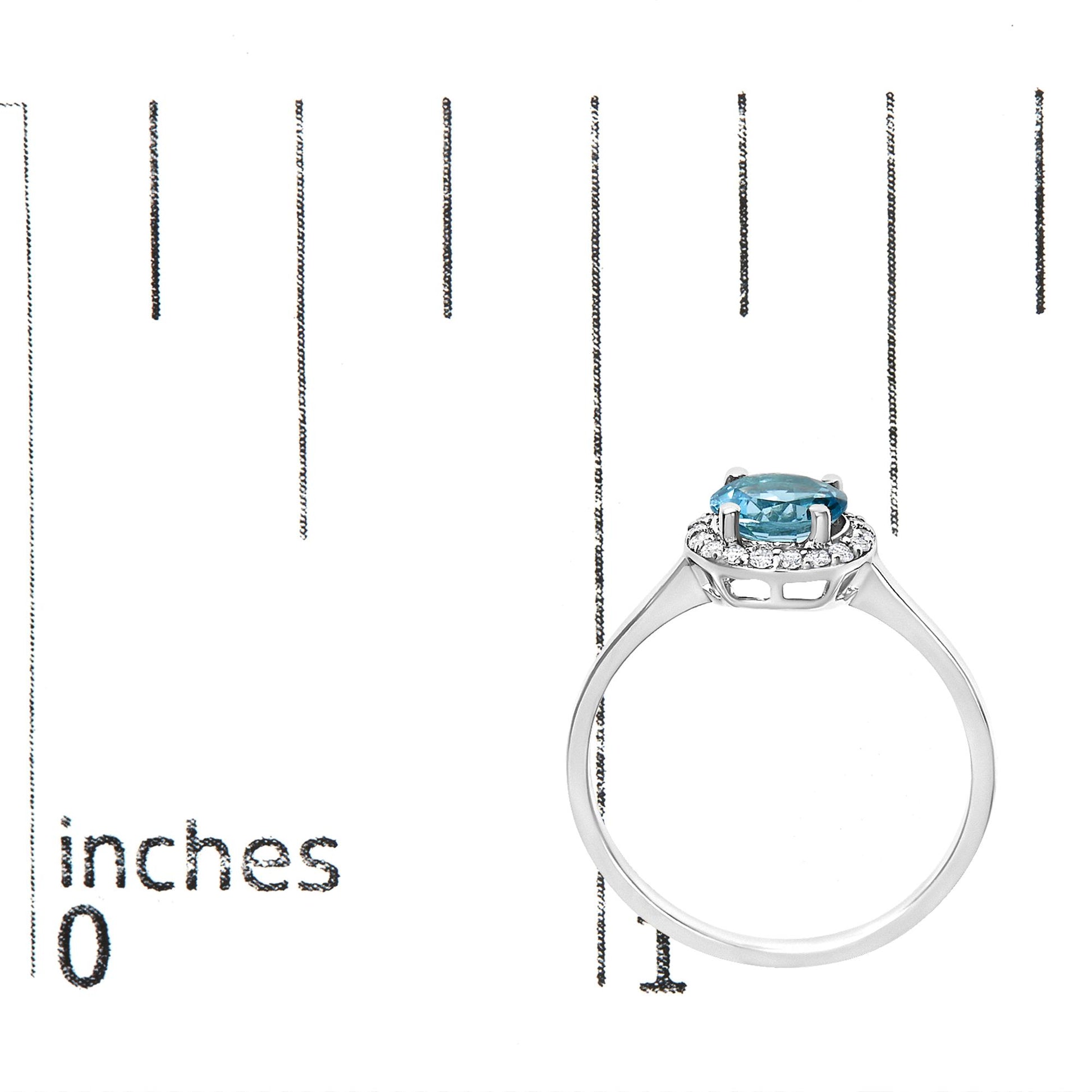 White metal ring with a round blue gemstone at the center surrounded by small round white gemstones in a shared prong setting, shown on a scale from a side angle.