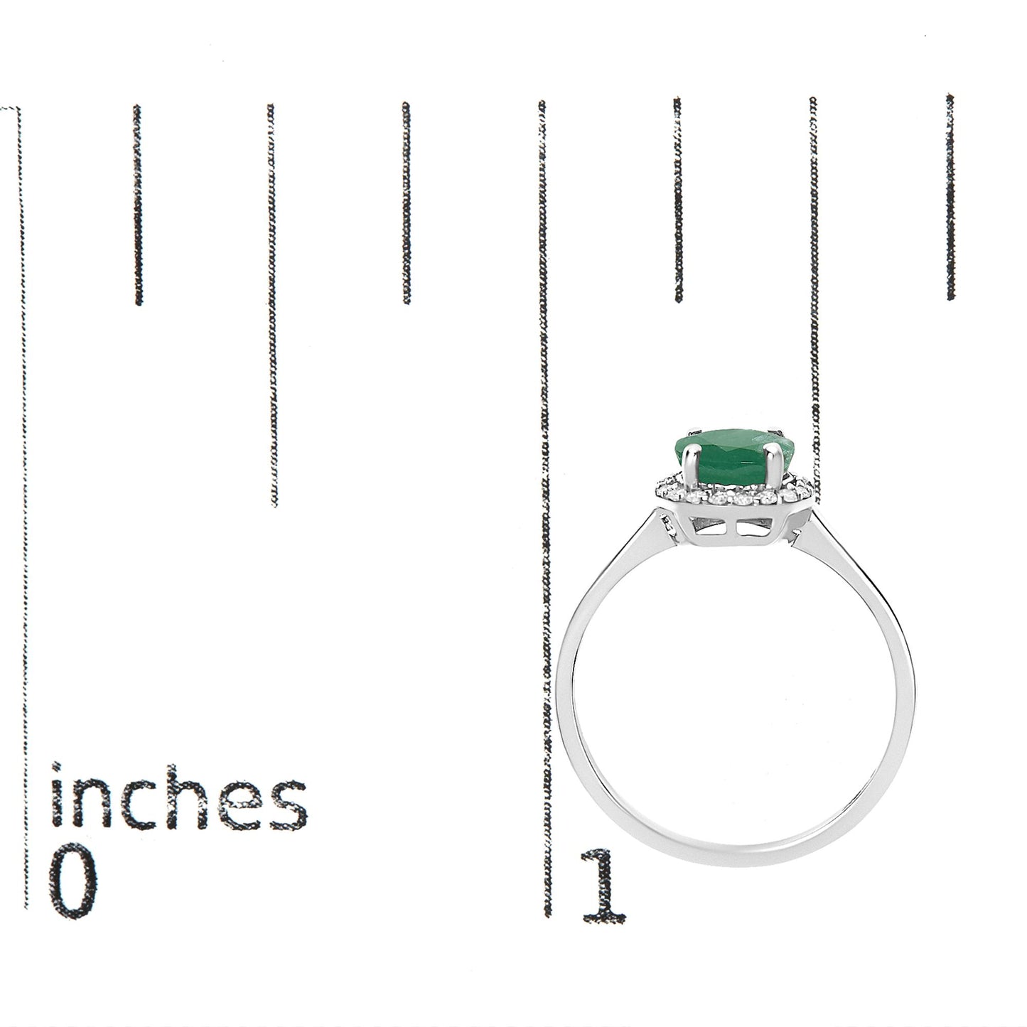 White metal ring with a round green gemstone in a four-prong setting, surrounded by multiple small white gemstones in a shared prong setting, shown on a scale from a side angle.