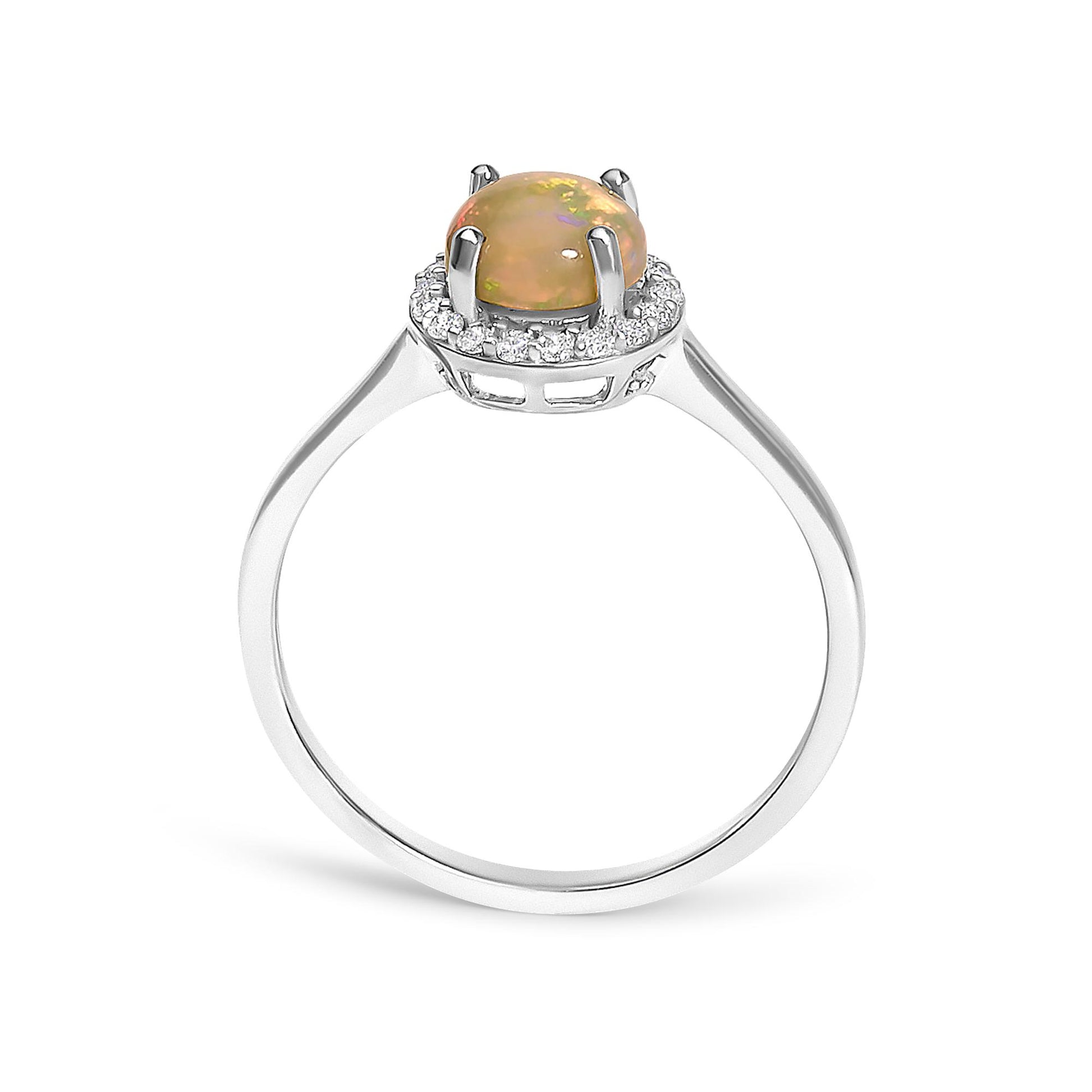 Front angle view of a white metal ring featuring a round multi-color opal gemstone in a four-prong setting surrounded by a halo of round white gemstones in shared prong settings.