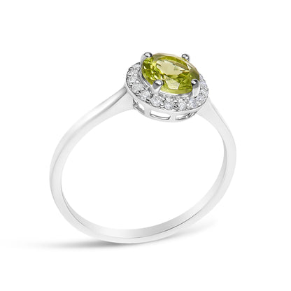 White metal ring with a round green gemstone at center surrounded by small round white gemstones in shared prong settings, shown at a slight angle.