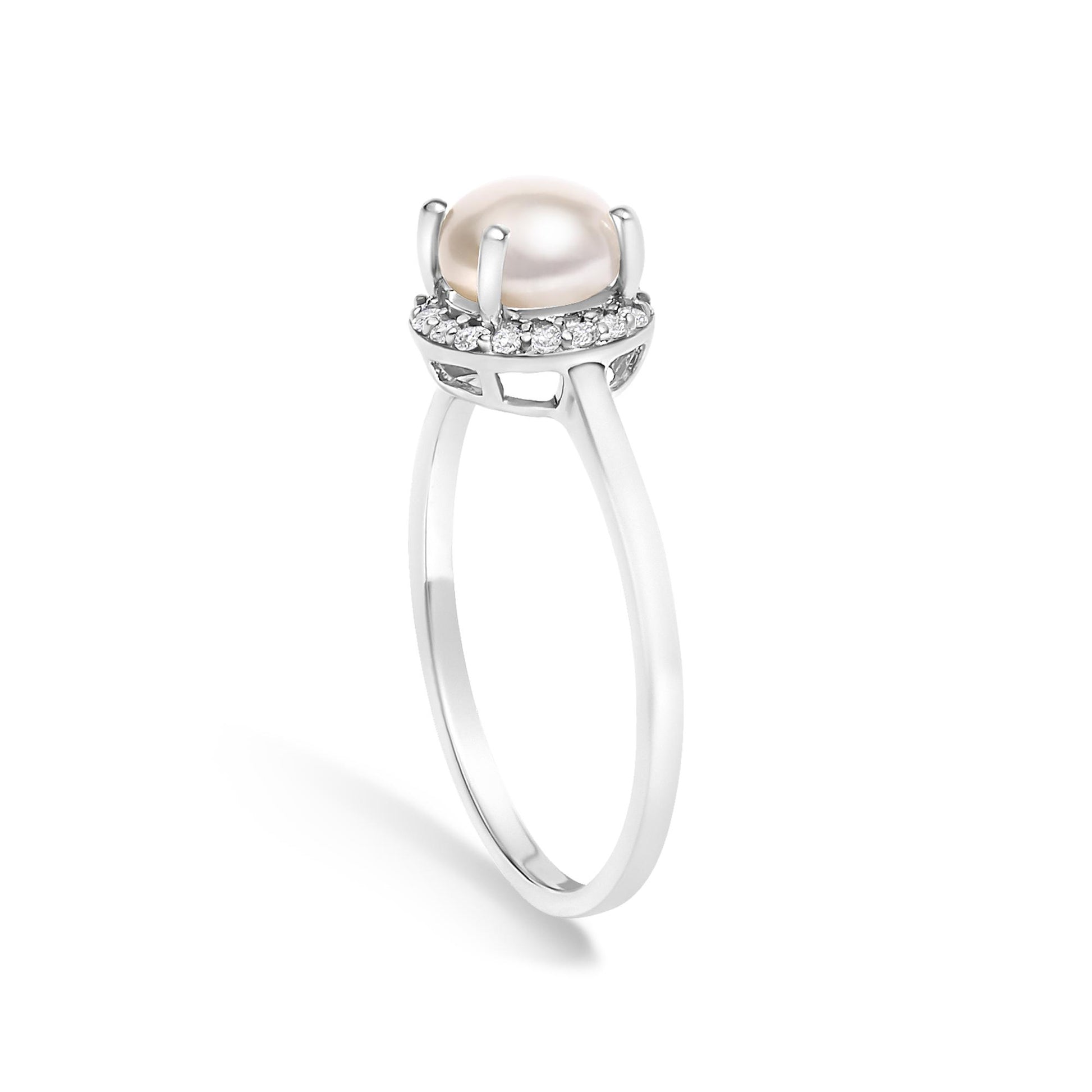 White metal ring shown from a side angle with a central rounded smooth pale gemstone held by four prongs, surrounded by a halo of small white round gemstones in a shared prong setting.