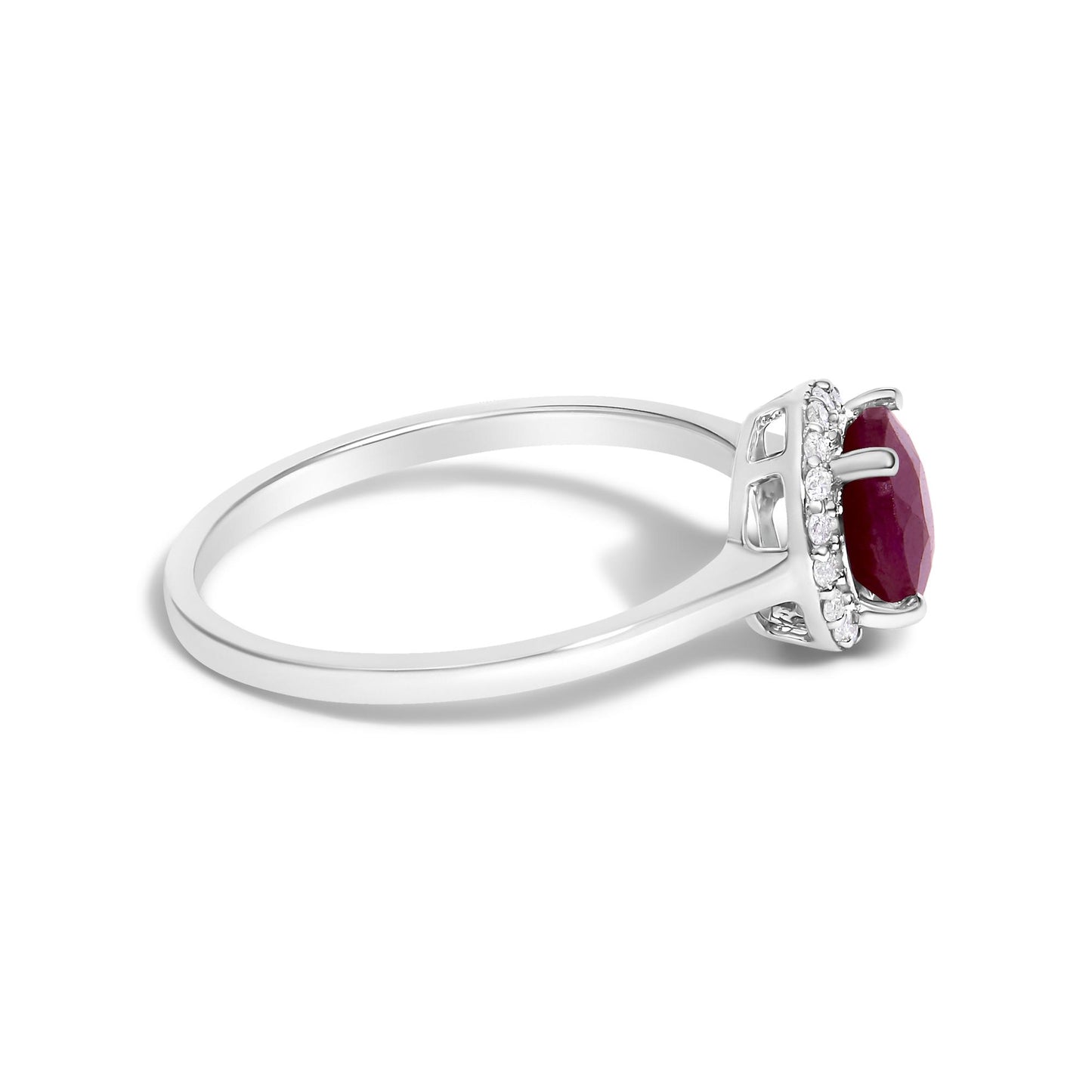 Side angle view of a white metal ring featuring a round red gemstone set in a four-prong setting, surrounded by multiple small white gemstones in a shared prong setting.