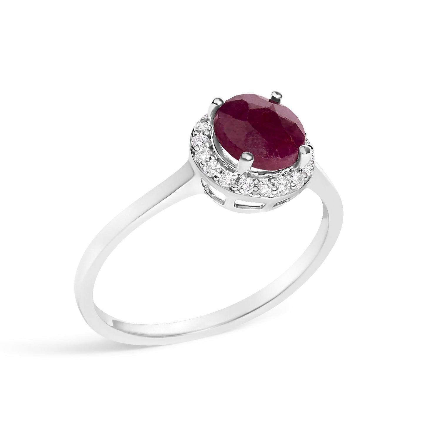White metal ring shown from an angled side view featuring a round red gemstone held by four prongs, surrounded by a halo of small round white gemstones in a shared prong setting.