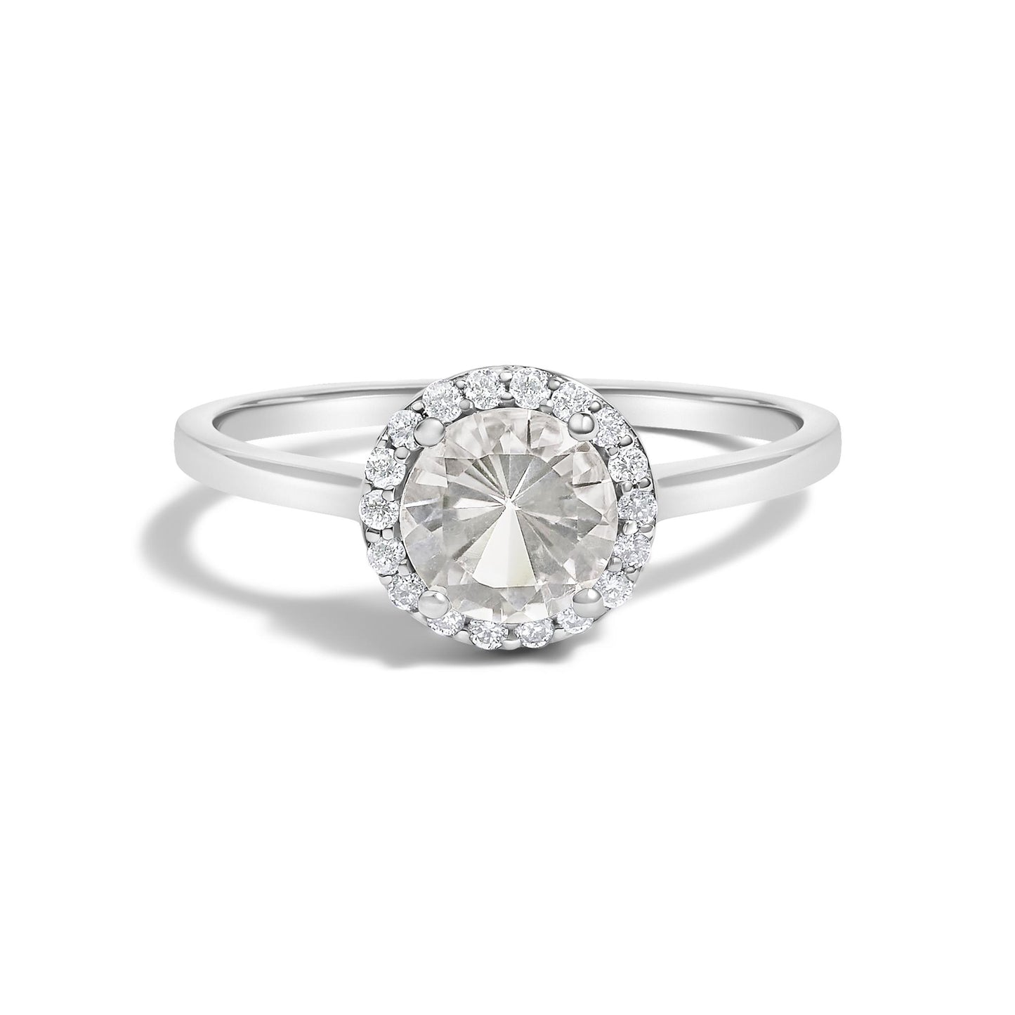 White metal ring with a central round white gemstone in a four-prong setting, surrounded by a halo of smaller round white gemstones in shared prong settings, shown in a front-facing close-up shot.