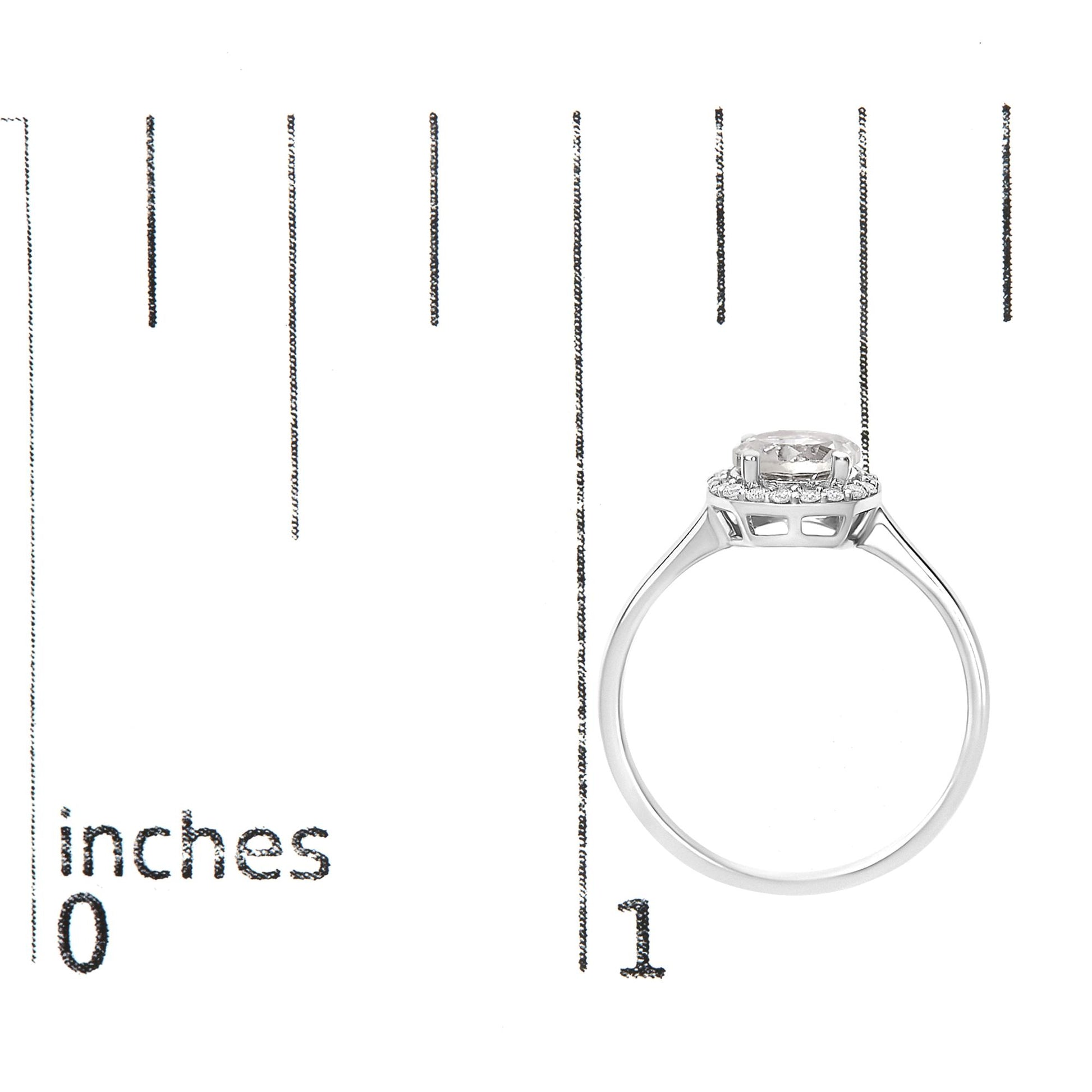 White metal ring with a round white gemstone center set in four prongs, surrounded by a halo of round white gemstones in shared prong setting, shown on a scale from a side angle.