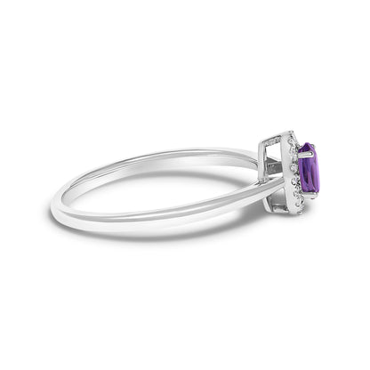 Side angle close-up of a white metal ring with an oval purple gemstone set in prongs, surrounded by a halo of small white gemstones in micro-pave setting.