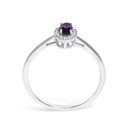 White metal ring with an oval purple gemstone in a prong setting at the center, surrounded by a circular halo of small white gemstones in a micro-pave setting, shown at a front angled view.