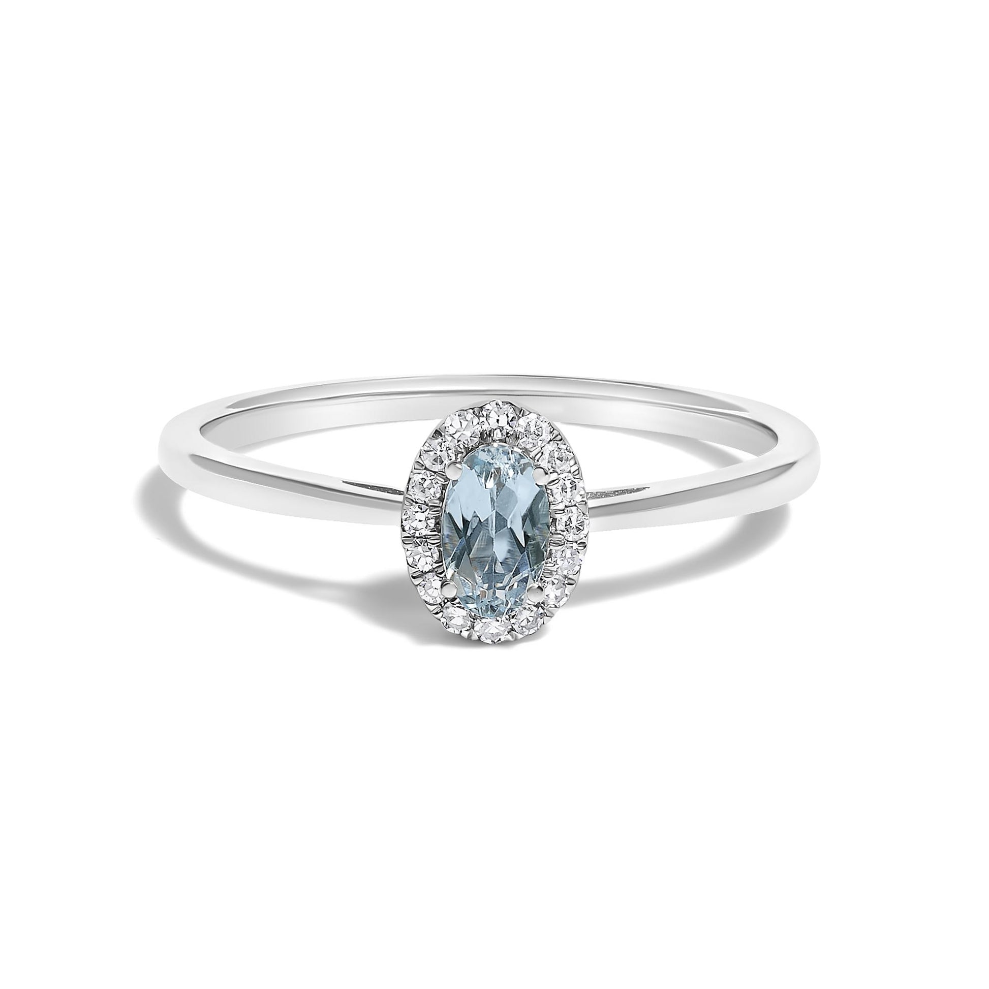 White metal ring with a blue oval gemstone center surrounded by small white round gemstones in a micro-pave setting, shown in a front-on angle.